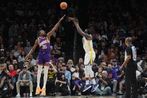 Partido entre Warriors y Suns, con Durant puntenando un tiro de Draymond Green